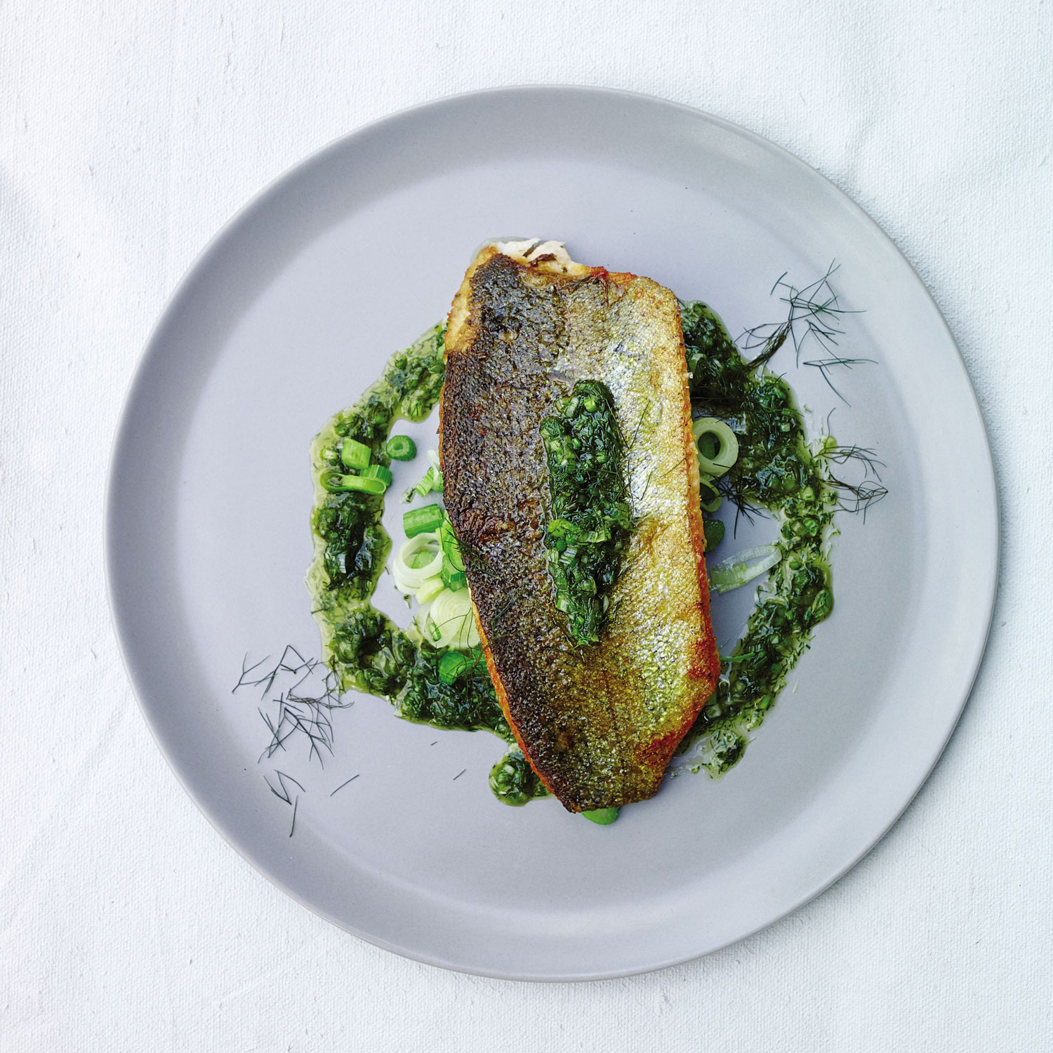 Trout fillets with sautéed fennel stems and fronds from “Root to Leaf” by Steven Satterfield. Photograph by John Kernick.
