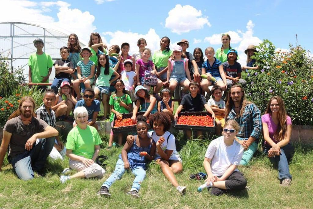 Haile Thomas with children on a farm