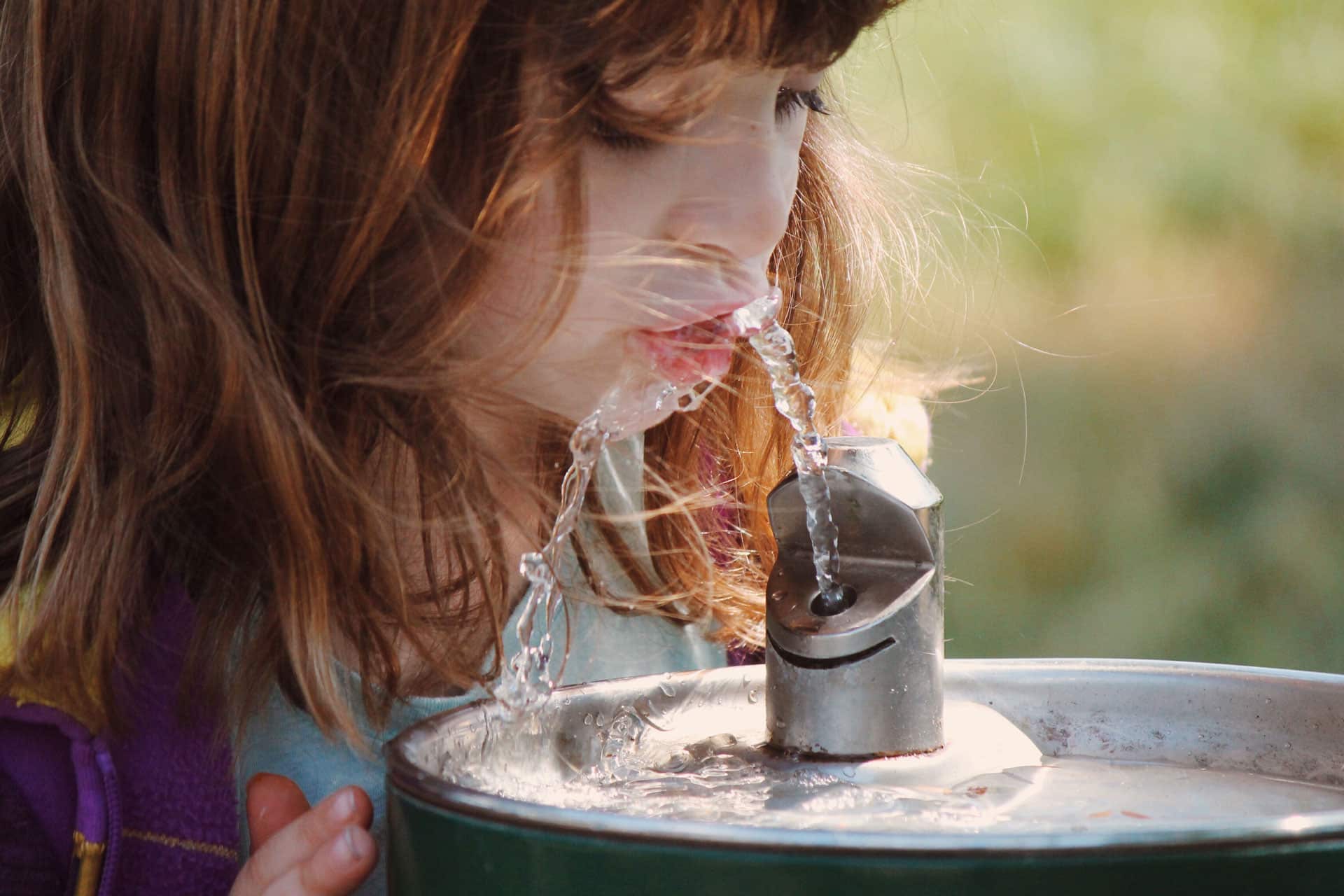 Girl drinking from water fountain